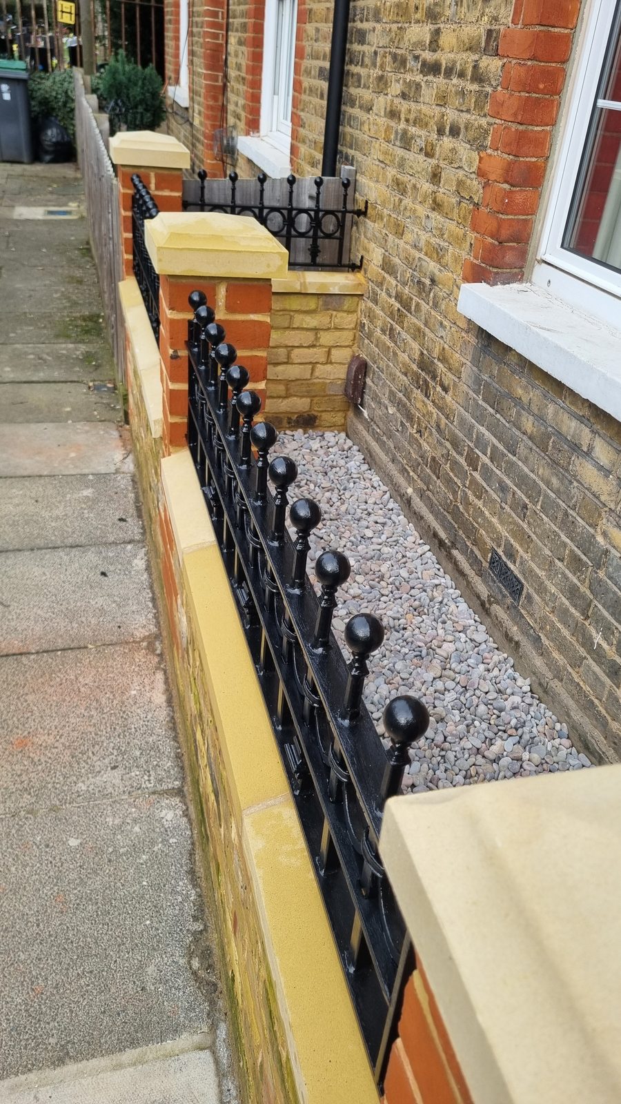 Cast iron, fitted into the brickwork. Hinges off the piers.